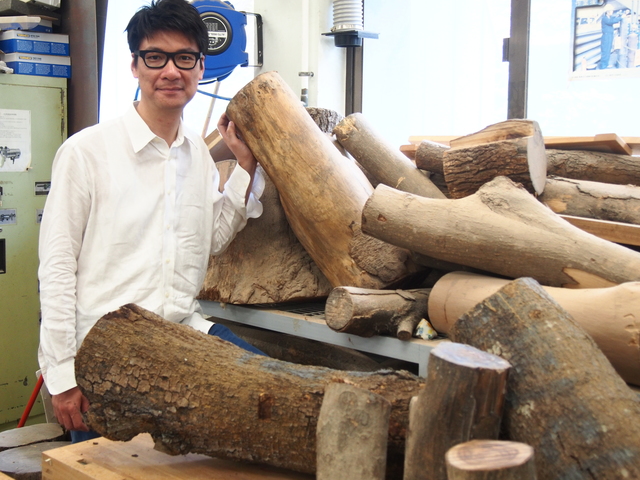艺术系助理教授谭伟平展示储存室的原木