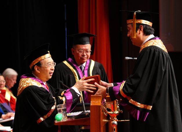 <b>Uneasy lies the head that wears a crown</b>, but Vice-Chancellor Prof. Joseph Sung, seen here receiving his seal of office from Dr. Vincent Cheng, the Council Chairman, has taken its weightiness in his stride.