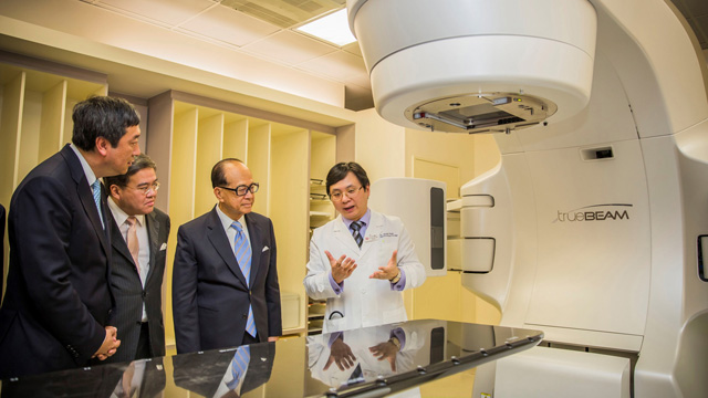Mr. Li Ka Shing and Mr. Anthony Wu listen to what the TrueBeam System, the most advanced radiotherapy technology for cancer treatment newly installed in the Prince of Wales Hospital, can do in the company of Prof. Joseph Sung