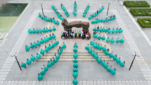 Students of Wu Yee Sun College, also known as 'The Sunny College', celebrate its fifth anniversary by forming a sun logo with umbrellas