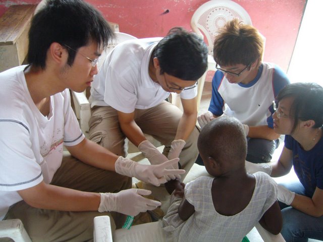 Heart to Heart Overseas Voluntary Service Scheme<br><br>Students dressing the wounds of a child